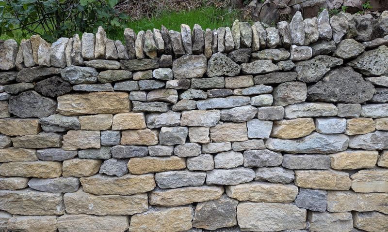 Dry stone wall with cock-and-hen coping